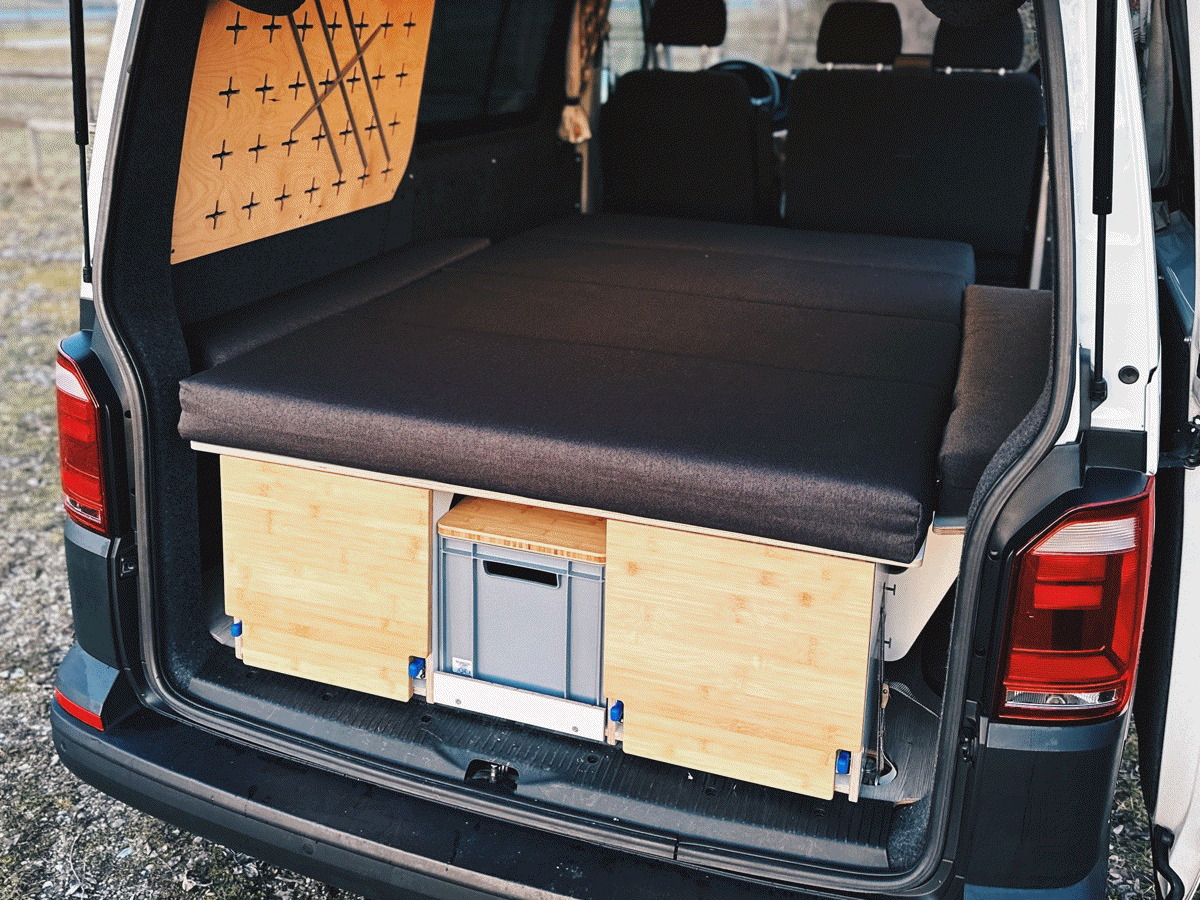 A camping box in the boot of a van, complemented by a flexible kitchen and storage space solution.
