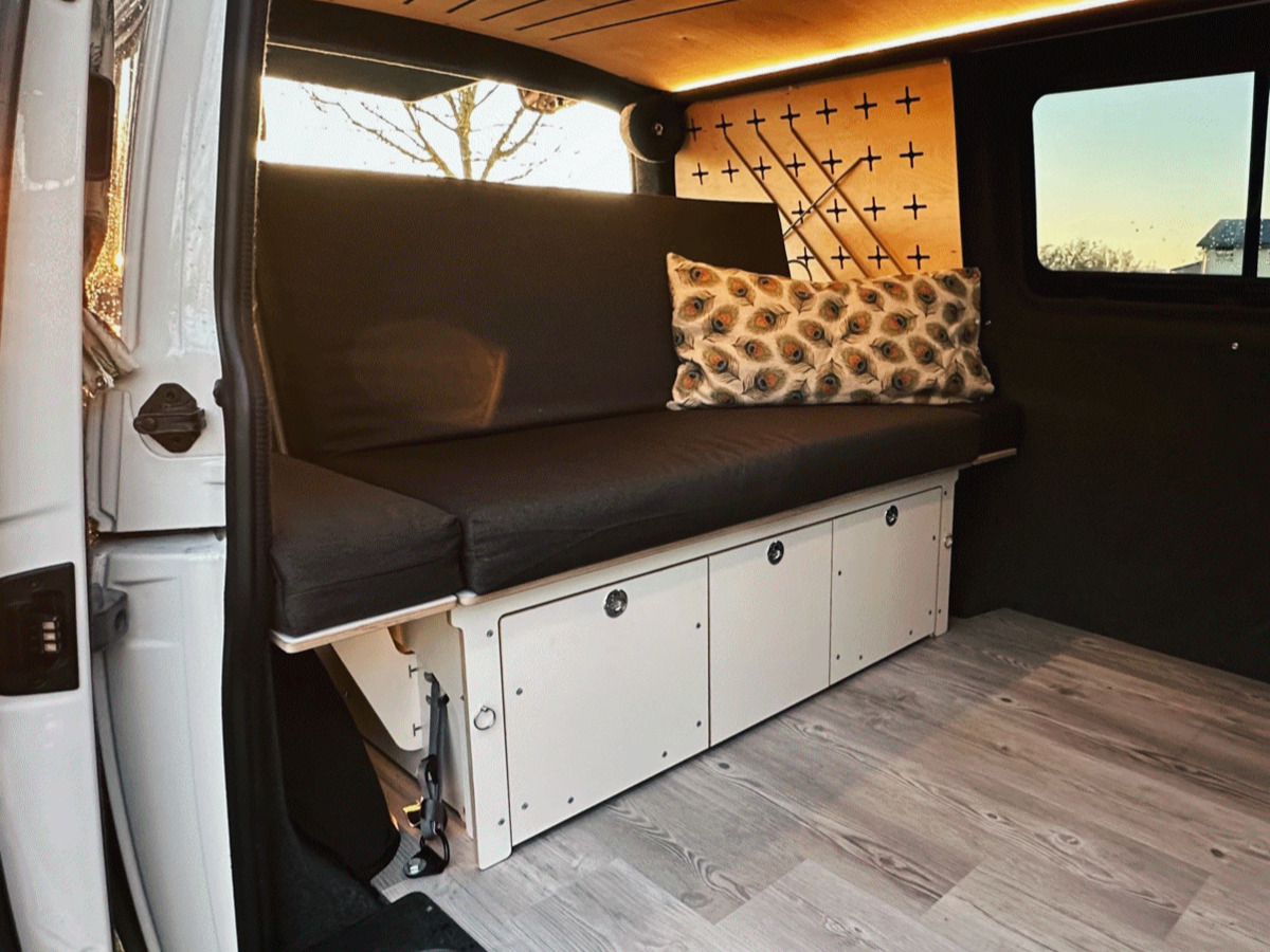 A comfortable and functional camping sofa with storage space, ideal for use in camping vehicles.