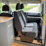 Interiér obytného vozu s otočenými sedadly.