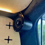 En kompakt højttaler er monteret på væggen i en campingvogn og er ideel til at nyde musik på camping.