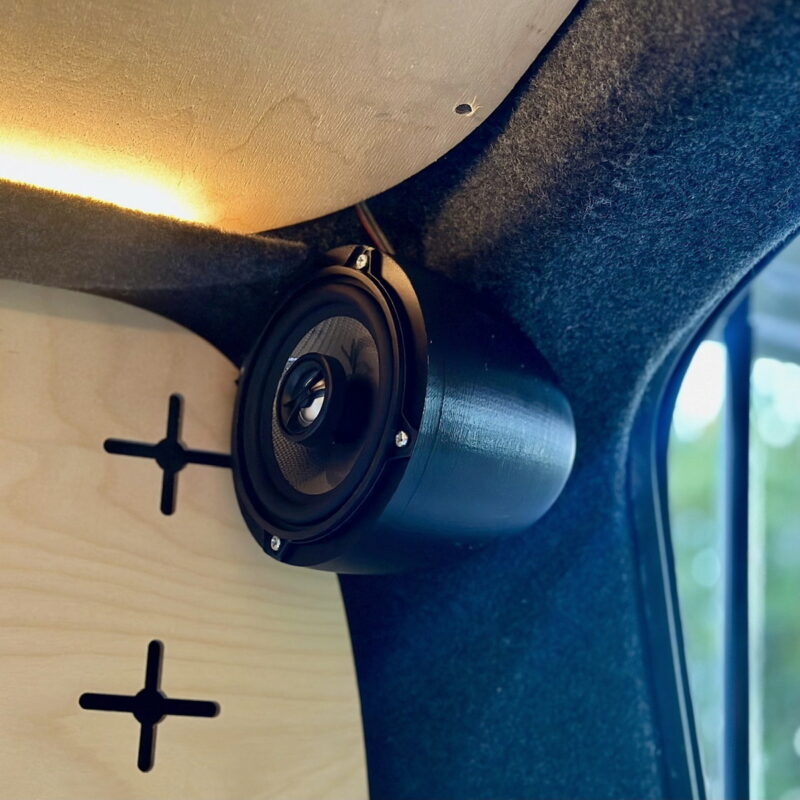 En kompakt højttaler er monteret på væggen i en campingvogn og er ideel til at nyde musik på camping.