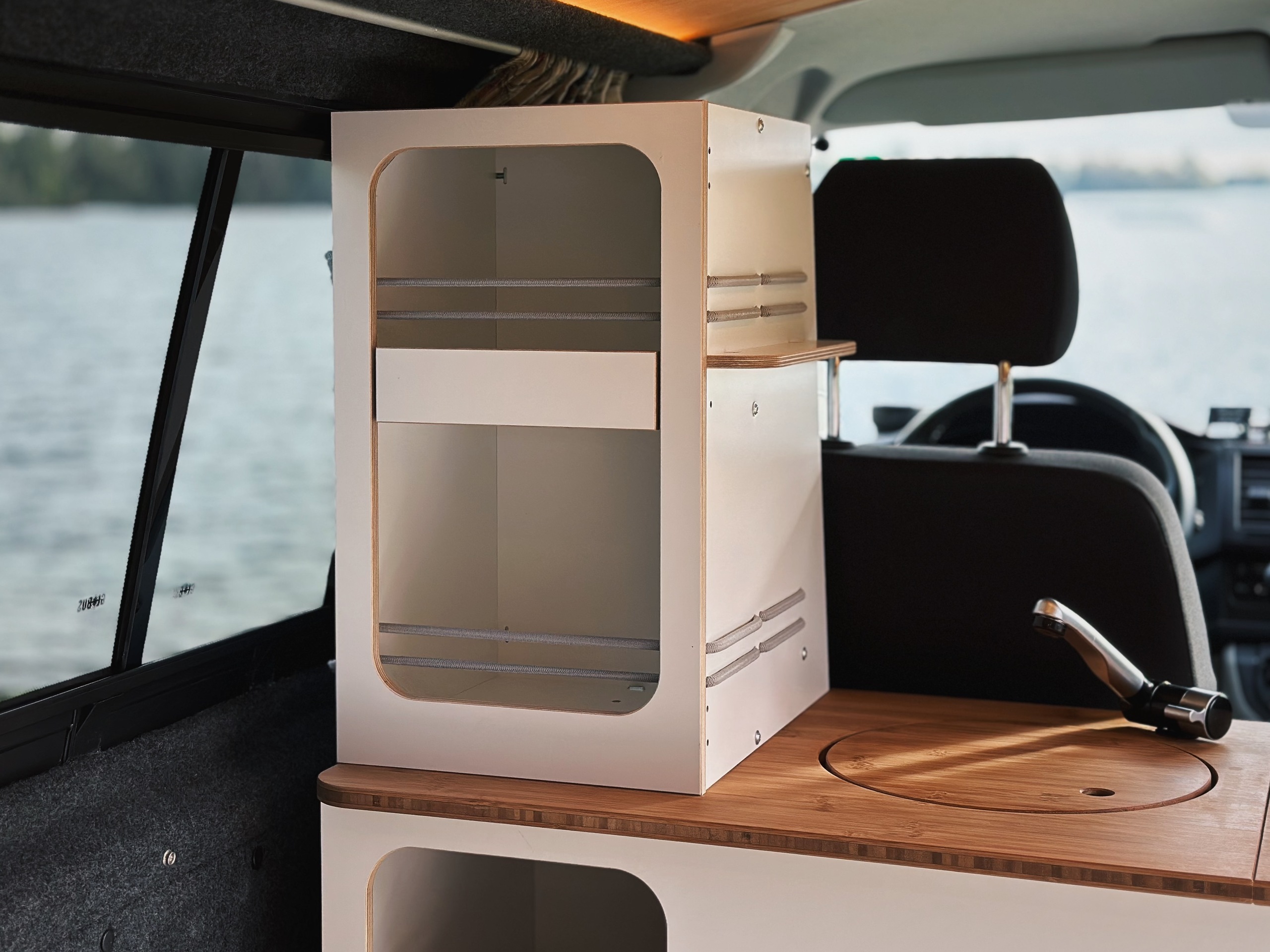 Elegantní kuchyňský modul pro obytná vozidla, který kombinuje úložný prostor s dřevěným povrchem a je ideální pro venkovní kuchyně.