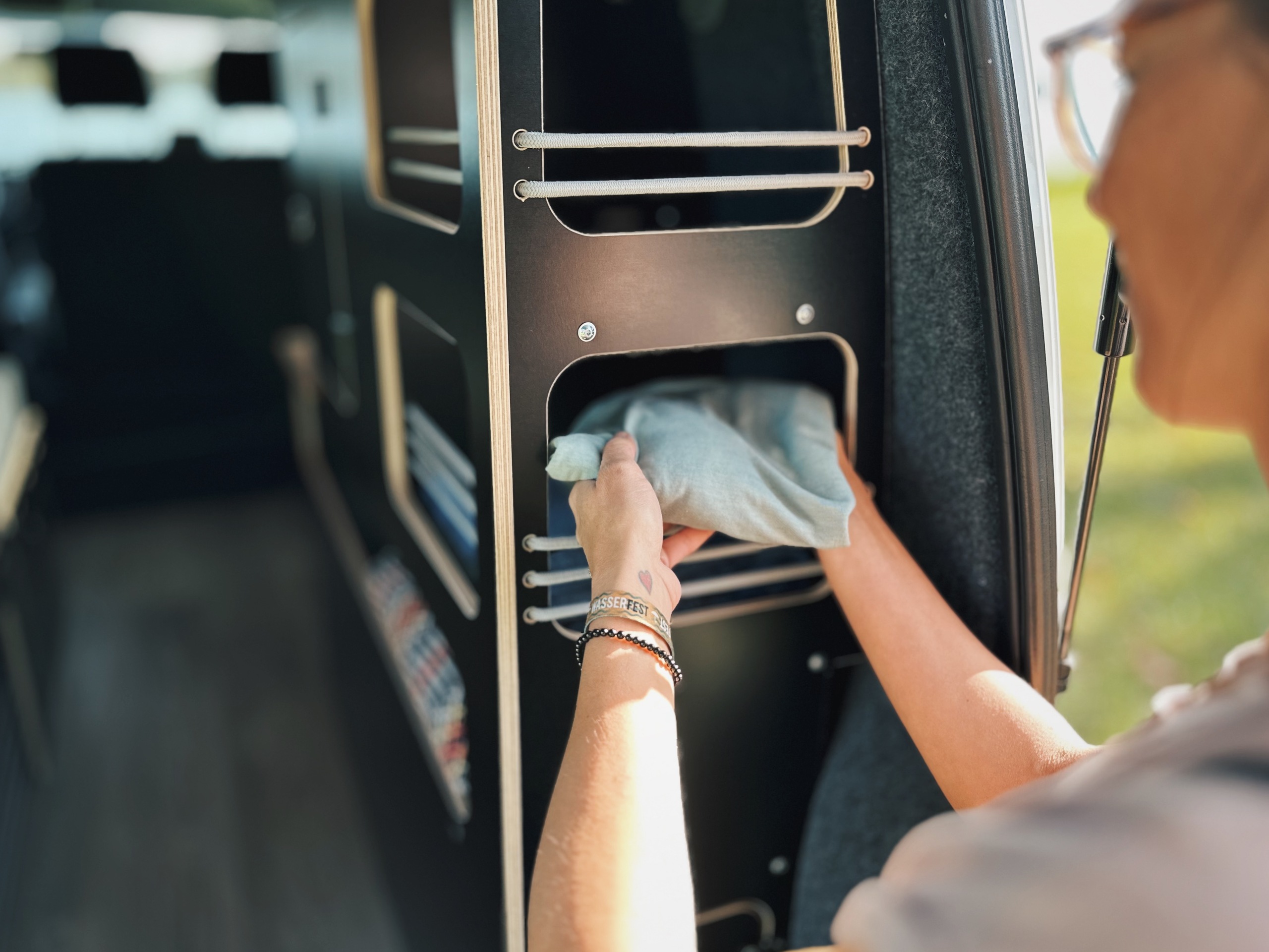 Do prostoru moderního kempingového nábytku instalovaného v dodávce umístí člověk látku.